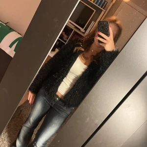 Svart fluffig pälsjacka - Säljer en svart, fluffig pälsjacka med lång ärm.