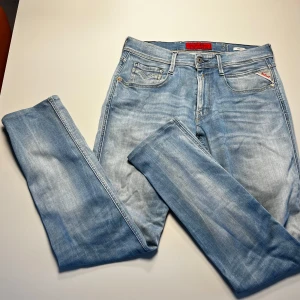 Replay Anbass ljusblå jeans herr - Ny pris 1900kr nu endast 350kr Säljer ett par Replay Anbass jeans i snyggt ljusblå tvätt. Klassisk femficksmodell med smal passform och diskreta slitningar. Jeansen har dragkedjegylf och är tillverkade i mjuk bomullsdenim med stretch för extra komfort.