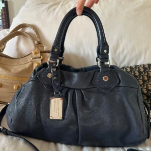 Mörkblå Q Classic Boston Bag - Köp via min vinted för bättre pris, plick tar så höga avgifter!🤍 Snyggaste mörkblå handväskan i bra skick från Marc by Marc Jacobs i äkta läder med silverdetaljer och dubbla handtag. Långa bandet medföljer. Mycket välbevarad vintage modell, fint skick. Stora modellen Q Classic Boston Bag. En MacBook 13’ får plats. Perfekt till skola, jobb eller fritid! Kan hämtas hemma hos mig i Nacka eller skickas🤍  Mått: 40x22x15