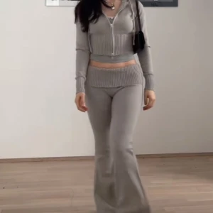 Grå ribbade byxor med kofta - Snygga grå stickade byxor med ribbad midja och bootcut-ben. Byxorna har låg midja och är gjorda i ett mjukt stickat material som ger en chill och trendig vibe. Perfekta för dig som gillar en avslappnad men ändå stilren look. Byxorna är i storlek XXS men då dom är stretchiga så hade de även passat XS och S. Koftan är i storlek XS. Settet är endast använd en gång. Skriv för mer info osv:)