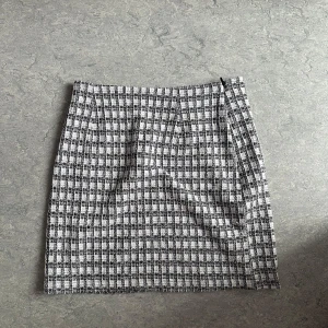 Rutig kortkjol från H&M Divided - Oanvänd. Skickar iväg samma dag eller dagen efter🙌🏼 Snygg kortkjol från H&M Divided i svartvitt rutigt mönster. Kjolen är gjord i ett mjukt polyestertyg. Perfekt att styla med en stickad tröja eller en cool jacka. Dragkedja i sidan för enkel påklädning.