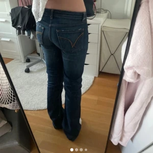 Bootcut jeans från Blend, mörkblå - Snygga mörkblå bootcut jeans från Blend i tight fit med låg midja. Klassisk femficksmodell med dragkedjegylf och coola kontrastsömmar. Tillverkade i stretchig denim av bomull och elastan för skön passform.