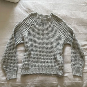 Ljusgrå stickad tröja med struktur - Säljer min supermysiga ljusgrå stickad tröja med grov struktur och ribbade muddar vid ärmslut, hals och nederkant. Den är i mycket bra skick och knappt använd