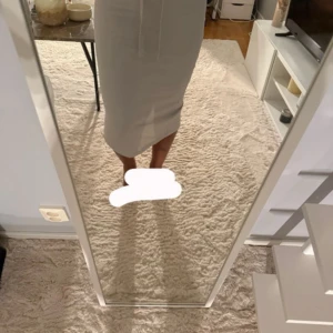 Crèmefärgad långkjol med snörning och slits - Säljer en Crèmefärgad långkjol i mjuk bomull med elastisk midja och snörning framtill. Kjolen har en rak passform och en snygg slits bak som ger extra rörelsefrihet. Perfekt för en chill och stilren look.