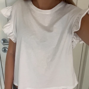 Vit volang T-shirt zara - Supersöt topp från zara, köpt för ungefär ett år sedan men har inte kommit till användning. Köpt för 100kr