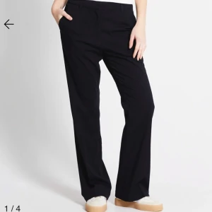 Svarta kostymbyxor med raka ben - Snygga svarta kostymbyxor med raka ben och klassisk passform. Byxorna har hällor för bälte och sidfickor, perfekta för en clean och stilren look. Passar till sneakers eller boots för en chill vibe.