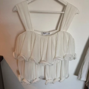 Vit plisserad linnetopp från NA-KD - Superfin vit linnetopp från NA-KD med breda axelband och plisserat tyg. 