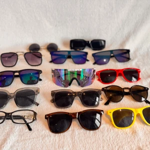 Fet samling solglasögon i olika färger - Säljer ett gäng snygga solglasögon i olika former och färger – allt från klassiska svarta och bruna till röda och knallgula bågar. Här finns både sportiga och retro modeller, vissa med spegelglas och andra med färgade bågar. Perfekt för dig som vill variera din stil! Styck pris 150kr 