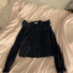  Blus från Gina Tricot i mörkblå färg med volang armar  -  Fin blus från dina Tricot med volang armar i färgen mörkblå 