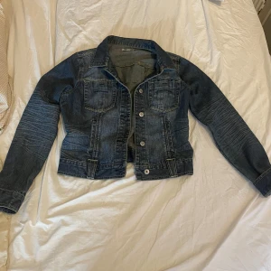 Mörkblå jeansjacka från Freequent - Snygg mörkblå jeansjacka från Freequent med klassisk krage, knappar framtill och två bröstfickor. Jackan har långa ärmar. Använd några gånger i storlek L