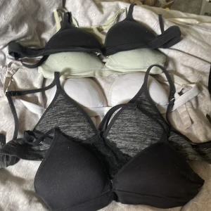 4-pack mjuka toppar i svart, grått, vitt & mint (barn storlek 150) - Fyra mjuka toppar med smala axelband i olika färger: svart, gråmelerad, vit och ljus mintgrön. Alla har vadderade kupor och stretchigt material, perfekta under en hoodie eller till chill-outfits. Säljes som paket!