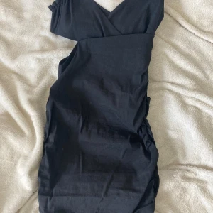 Svart omlottklänning från Zara  - Snygg svart kortklänning från Zara i omlottmodell med v-ringning. Klänningen har en figurnära passform och är ärmlös, perfekt för dig som gillar stilrena och enkla plagg. Materialet känns mjukt och lätt mot huden. Är i storlek xs men är insydd