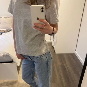 Grå basic t-shirt i bomull - Enkel och stilren grå t-shirt med korta ärmar och rund hals. Modellen är rak och har en avslappnad passform, perfekt till jeans eller shorts. 