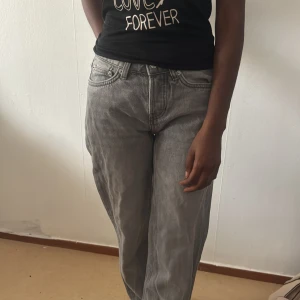 Gråa loose fit jeans - Säljer ett par gråa jeans med loose fit och raka ben. Jeansen har klassisk femficksdesign, bälteshällor och dragkedjegylf. Perfekta för en avslappnad och trendig look. Materialet är jeans och färgen är en snygg tvättad grå.