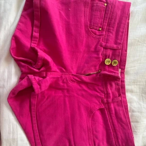 Super lowwaist jeansshorts - Snygga chockrosa jeansshorts från g perfect jeans med låg midja, guldiga knappar och klassiska fickor både fram och bak. Shortsen har dragkedja och bälteshällor, perfekta för att sticka ut i sommarvärmen.