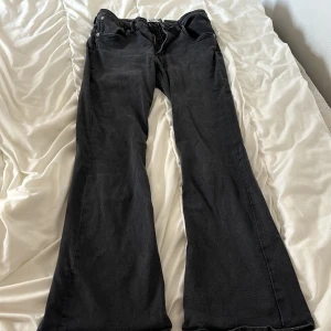 Svarta bootcut jeans från 157, XL - Svarta jeans från 157 i bootcut-modell med klassisk femficksdesign. Jeansen har normal passform och är tillverkade i ett mjukt bomullstyg med dragkedjegylf. Perfekta för dig som gillar en retroinspirerad look med utsvängda ben. Dom har vart mörkare tidigare men har blivit lite ljusare/gråa efter tvätt. Jag är 182cm lång, dom är lite för korta för mig så är perfekt längd för dig som är ungefär 170 - 175cm lång.