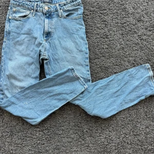 Ljusblå jeans från Jack & Jones - Säljer ett par klassiska ljusblå jeans från Jack & Jones, modell Clark. Jeansen har rak passform, fem fickor och snygga kontrastsömmar. Perfekta för dig som gillar en enkel och tidlös stil. Materialet är mjukt denim i bomull.w 29 / l30