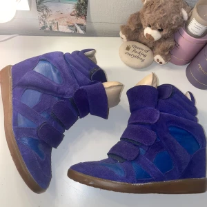Isabel Marant skor  - Pris: 2700 kr  Säljer dessa sjukt snygga Isabel Marant skor i lila/blå 💜 Dom är i storlek 37 och har en inbyggd klack så man blir ungefär 4cm längre men ändå sköna att gå i 😍  Lite grå inuti men inget man märker när man har dom på, annars i jättefint skick! Går typ inte att hitta längre i den här färgen så passa på 🤗  💌 Skriv om du vill ha fler bilder eller har frågor!
