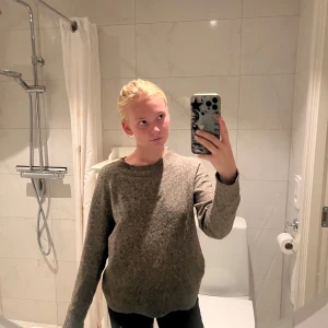 Beige stickad tröja med rund hals - Mysig beige stickad tröja med rund halsringning och långa ärmar. Tröjan har en enkel och avslappnad passform, perfekt att slänga på sig när det är kyligt. Materialet känns mjukt och värmande, och färgen är lätt att matcha med det mesta.