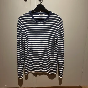 Randig stickad tröja från J.Lindeberg - Säljer en blåvit randig stickad tröja från J.Lindeberg i nyskick. Endast använt den vid fåtal tillfällen. Storlek S.