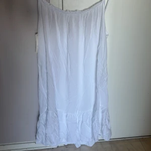 Vit sommarklänning med volang - Säljer en luftig vit klänning med smala axelband och volang nertill. Ingen exakt storlek på skulle säga M. Perfekt för varma dagar och enkel att styla med accessoarer. Klänningen är från New Collection och har en avslappnad passform.