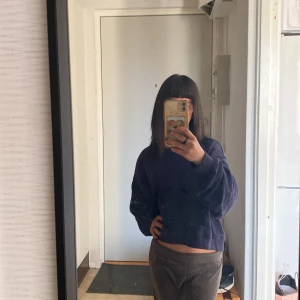 Mörkblå croppad sweatshirt från H&M Divided - Säljer en mörkblå från H&M Divided. Tröjan har långa ärmar, rund halsringning och är tillverkad i mjuk bomullsmix. Tröja är i storlek XL, men om han vill ha den lite baggy så funkar den i storlekarna xs/s/m och L (själv har jag xs/s) och den sitter fint ❤️