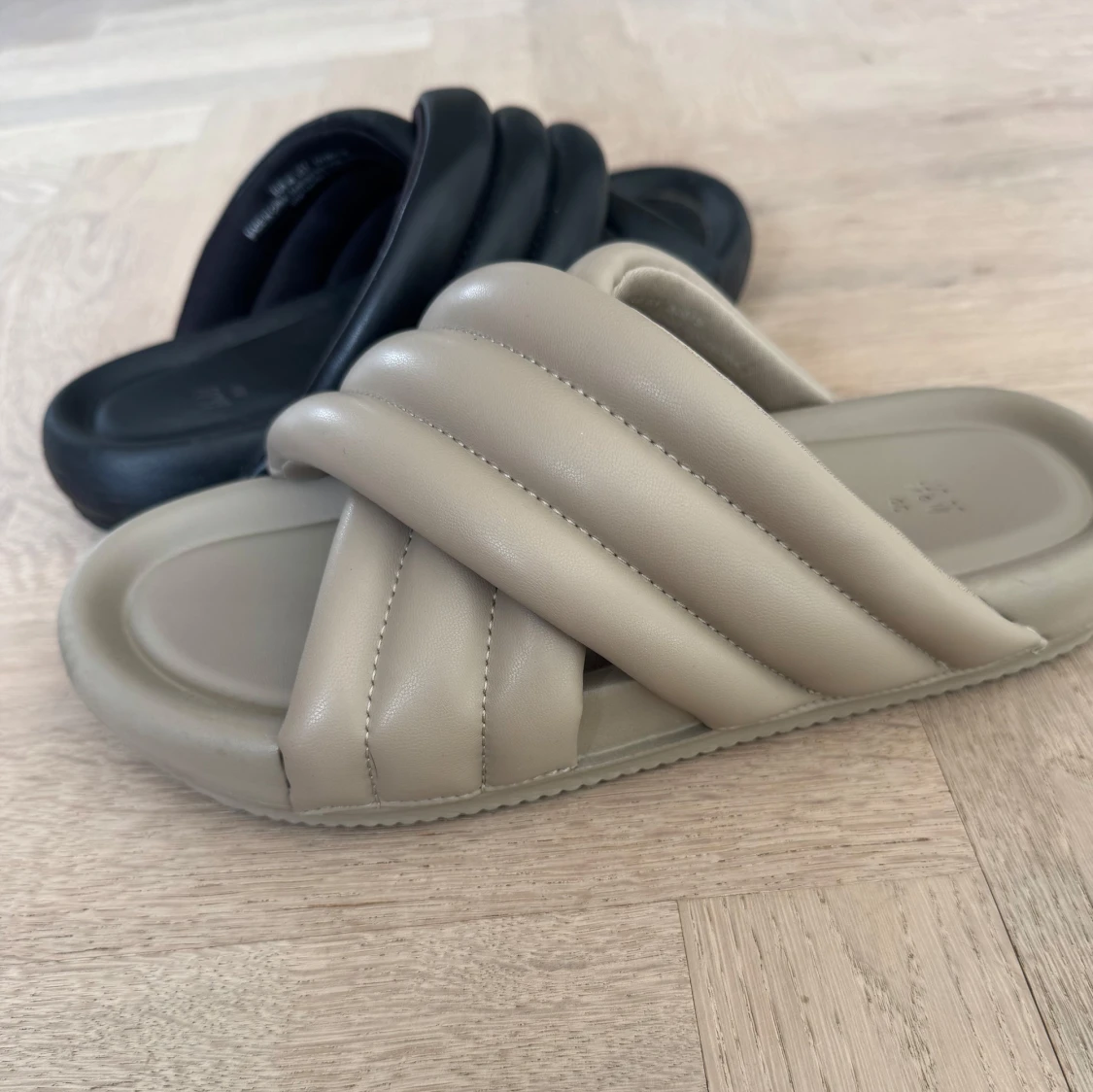 Beige och svarta sandaler med vadderade remmar
