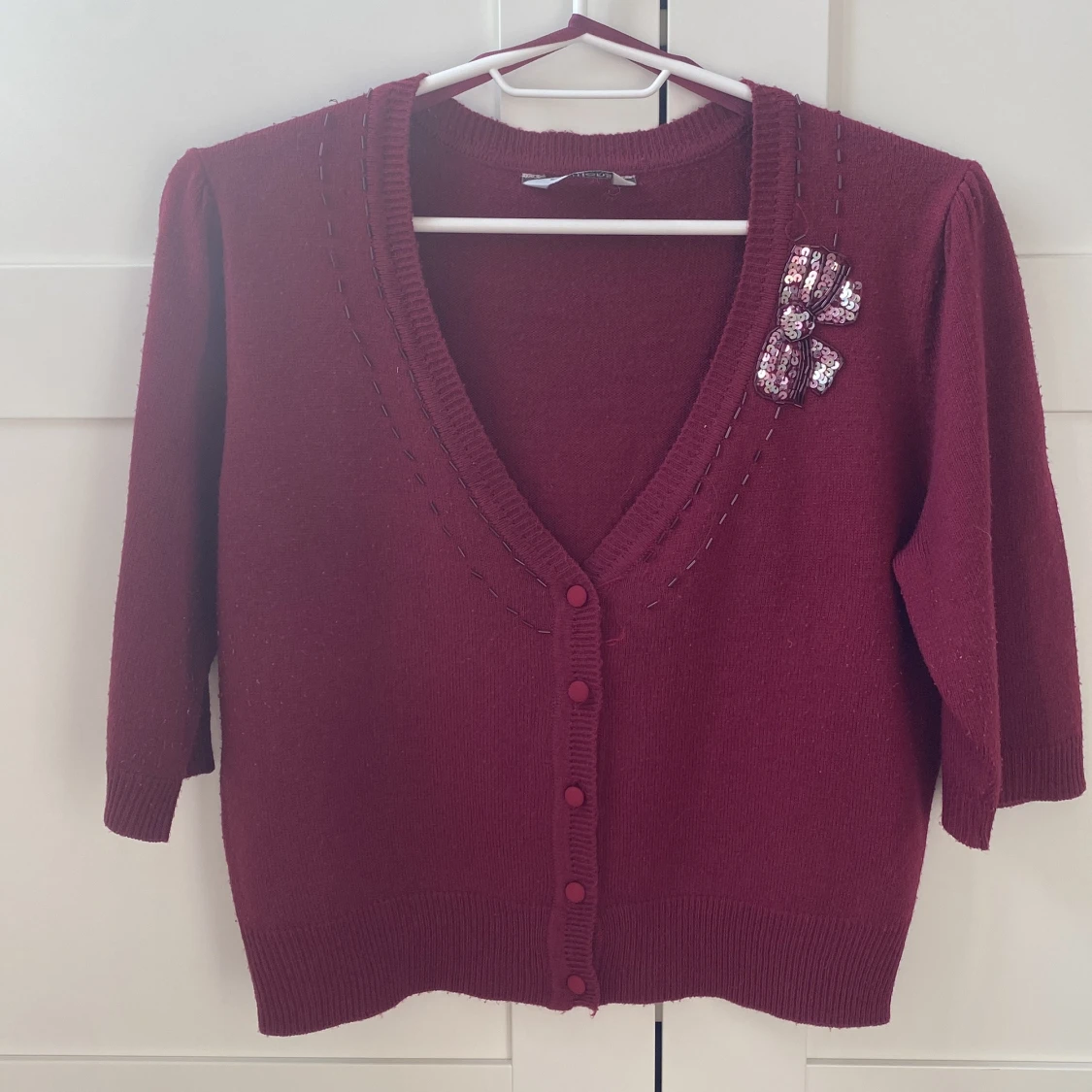 Vinröd kofta med dekorativ rosett