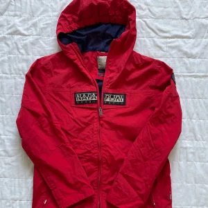 Napapijri windbreaker - Säljer nu min röda napapijri windbreaker som blivit för liten! | Skicket är som på bilderna alltså bra. | Enda möjliga defekt är att dragkedjan är seg men om man är försiktig och tar det långsamt är det inga problem att dra upp och ner! | Jackan tål vissa mängder vatten och är i storlek 162 cm. | Skulle väl kunna motsvara XXS/XS. | Nypris ca 1200+ kr. |Släng iväg en signal vid funderingar så svarar jag snabbt. |