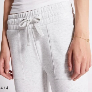 Grå mjukisbyxor med snörning - Säljer ett par bekväma grå mjukisbyxor med elastisk midja och snörning. Byxorna har fickor både fram och bak, perfekta för en avslappnad stil.