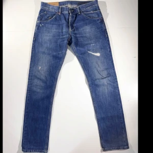 🔥blå Dondups 🔥 - Säljer ett par klassiska blå jeansbyxor från Dondup med passform slimfit och snygga slitningar. Byxorna har knappar i gylfen, fem fickor och kontrastsömmar. Perfekt för dig som vill ta din garderob till nästa nivå! 