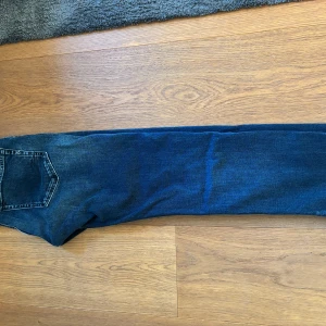 Mörkblå Replay Grover jeans - Säljer ett par mörkblå Replay Grover jeans med klassisk femficksdesign och lätt slitna detaljer. Jeansen har slim/raka ben och normal passform, perfekta för en avslappnad stil. 31/30