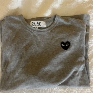 Grå långärmad tröja från Comme des Garçons  - Säljer en grå långärmad tröja från Comme des garçons. Tröjan är sparsamt använd och därför i fint skick! Den är liten i storleken, skulle säga att den är mer som en M. Nypris är 1049kr 💕 Kan självklart skicka fler bilder om det önskas☺️
