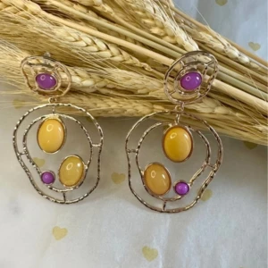 Stora statement örhängen med gula och lila stenar - Unika örhängen i guldtonad metall med abstrakt form. De har stora ovala gula stenar och mindre runda lila stenar. Perfekta för dig som vill sticka ut med färg och form.