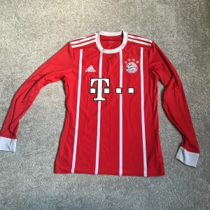 Bayern München 17/18 långärmad fotbollströja - Röd långärmad Bayern München fotbollströja från Adidas med vita ränder och detaljer. Klubblogga och sponsortryck på framsidan, samt 'Bayern München' tryckt på ryggen. Tillverkad i lätt och ventilerande material (Climacool). Är använd men har inga fel. Köparen står för frakt. Medela mig om du har några frågor!