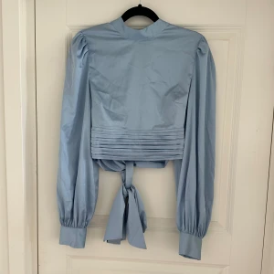 Satin topp NAKD - Jättefin satintopp med öppen rygg och knytning bak. Helt oanvänd med lappen på! 