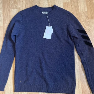 Mörkblå kashmirtröja Zadig & Voltaire - Säljer en mörkblå kashmirtröja från Zadig & Voltaire med rund hals och långa ärmar. Tröjan har svarta ränder på ena ärmen och ribbade muddar. Perfekt för dig som gillar stilrena och lyxiga plagg. Nypris runt 4000. Säljer då jag tröttnade på den medans jag hade tänkt att växa in i den. Tar emot byten