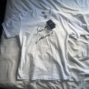 Vit t-shirt från Saint Laurent - Säljer en vit t-shirt från Saint Laurent. Storlek M men sitter exakt som S. Passar mig som är 177