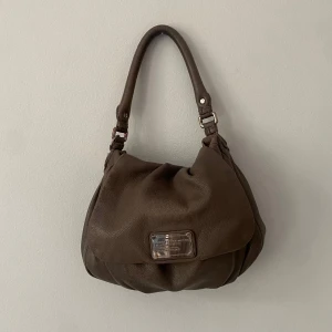 Marc Jacobs väska - Fin väska från Marc by Marc Jacobs. Några små tecken på slitningar (se bilderna) och lite missfärgning på undersidan av axelbandet,  inget man tänker på så mycket när man har väskan på sig. 