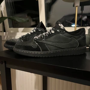 Svarta Nike sneakers med vit kontrastsöm - Säljer ett par black phantom Travis scott X Nike X Jordan. Box tillkommer ej, inga extra skosnörren och sulan på vänster sko saknas. Övrigt är dem acceptabelt skick (Inte @kta)