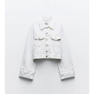 Vit  jeansjacka med uppvikta ärmar från Zara - Säljer en vit oversize  jeansjacka från Zara med klassisk krage och knappar framtill. Jackan har två bröstfickor med lock och långa uppvikta breda ärmar. Aldrig använt 