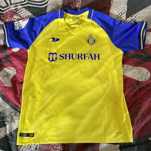 Al Nassr fotbollströja Ronaldo 7 - Säljer en officiell Al Nassr fotbollströja med Ronaldo 7 på ryggen. Priset kan diskuteras fråga mer för måtten