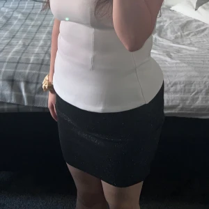 Svart glittrig kortkjol - Säljer en svart glittrig kortkjol med slim passform. 