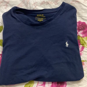 Mörkblå t-shirt från Polo Ralph Lauren - Klassisk mörkblå t-shirt från Polo Ralph lauren. Tillverkad i mjuk bomull för en skön känsla. Perfekt till jeans eller shorts. Använt 1-3 gånger så den är i bra skick.