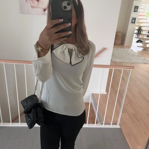 Vit blus med rosett och svarta kanter - Säljer en vit blus med lång ärm och stor rosett vid halsen som har svarta kanter. Aldrig använd endast testad, köpt på Zara basic, finns ej kvar på Zara🥰