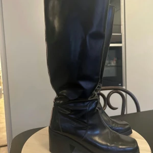 Stövlar/Boots & Other Stories 38 - Ett par stilrena svarta stövlar från & Other Stories.  Bekväm klackhöjd som gör dem lätta att gå i. Ljusbrun insida och lätta att dra på. Storlek 38. 