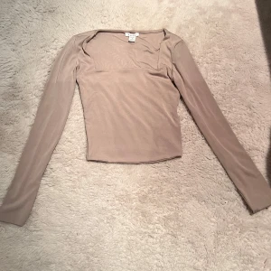Beige långärmad tröja från New Yorker - Säljer en stilren beige långärmad topp från new yourker men märket AMISU Toppen har en fyrkantig ringning och stretchigt material som sitter snyggt o mysigt Perfekt att matcha med jeans eller kjol men även shorts💗