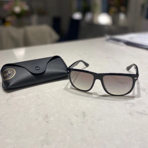 Svarta solglasögon från Ray-Ban -  svarta solglasögon Ray-Ban boyfriend (köpta på synsam) med rektangulära bågar och svart tonade linser. Kommer med originalfodral, putsduk och certifikat. Dem ser ljusare ut i glasen än vad dem är. Kan skicka fler bildar om man vill!