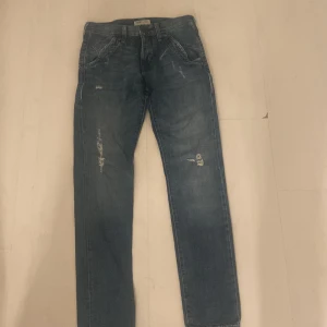 Blå jeans från Lee Women - Säljer ett par klassiska blå jeansbyxor från Lee Women med raka ben och lätt slitna detaljer framtill. Jeansen har normal passform.Perfekta för en avslappnad stil.