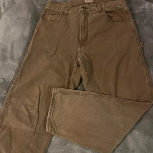 Vintage Bruna arbetsbyxor från Schmidt - Bruna vintage jeans köpta i Paris i storlek 38 (men sitter som en 36), längd 32. Har typ aldrig använts av mig och köptes med en fläck på ena knät. För fler frågor eller bilder skriv till mig privat!